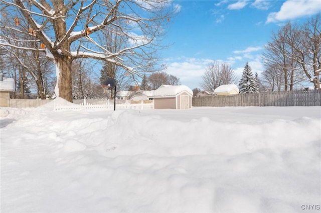 yard covered in snow featuring a shed