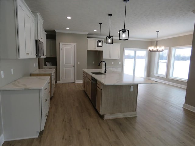 kitchen with appliances with stainless steel finishes, sink, white cabinets, a large island with sink, and light stone countertops