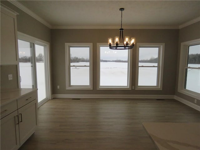 unfurnished dining area with crown molding, dark wood-type flooring, and an inviting chandelier