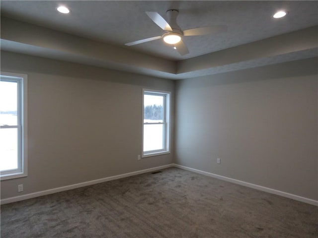 unfurnished room featuring dark colored carpet and ceiling fan