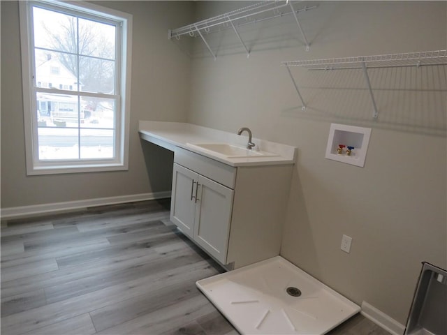 laundry area featuring sink, washer hookup, and light wood-type flooring