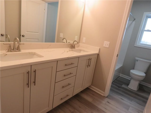 bathroom featuring wood-type flooring, toilet, and vanity