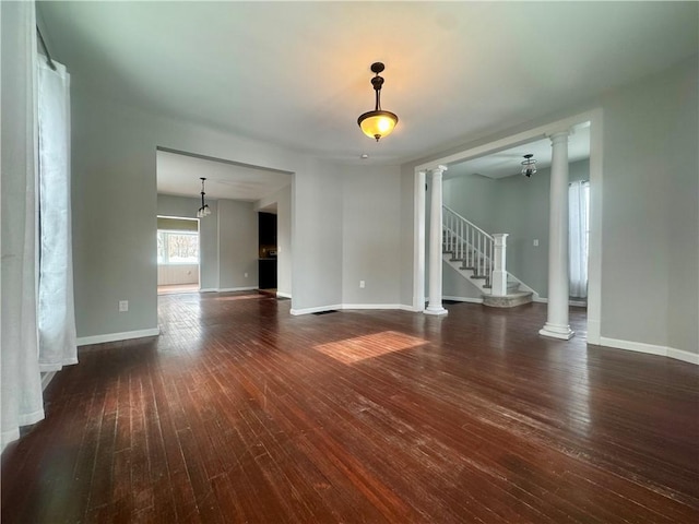 empty room with ornate columns and dark wood-type flooring