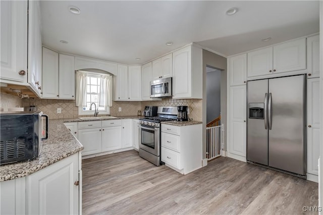 11190 US Route 11, Adams, NY 13605 - kitchen with sink, light hardwood / wood-style flooring, stainless steel appliances, light stone counters, and white cabinets