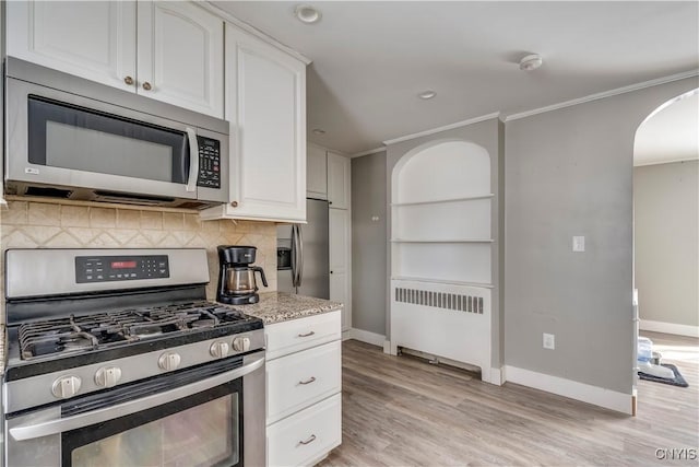 11190 US Route 11, Adams, NY 13605 - kitchen featuring white cabinetry, radiator, decorative backsplash, and stainless steel appliances