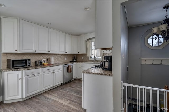 11190 US Route 11, Adams, NY 13605 - kitchen featuring stainless steel appliances, a sink, light wood-type flooring, decorative backsplash, and white cabinets
