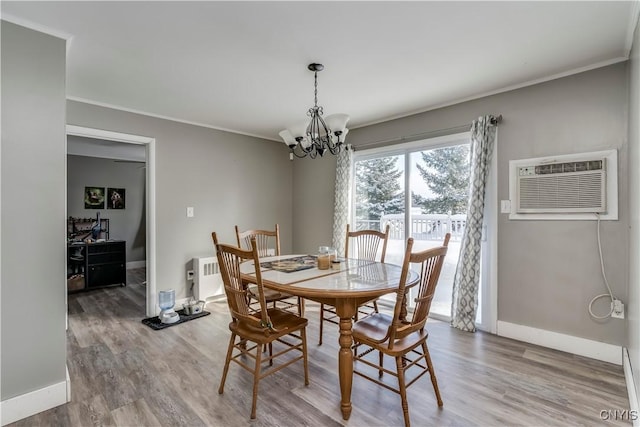 11190 US Route 11, Adams, NY 13605 - dining area featuring a chandelier, an AC wall unit, wood finished floors, ornamental molding, and baseboards