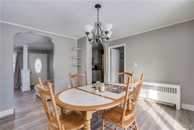 11190 US Route 11, Adams, NY 13605 - dining space with arched walkways, radiator heating unit, ornamental molding, light wood-type flooring, and baseboards