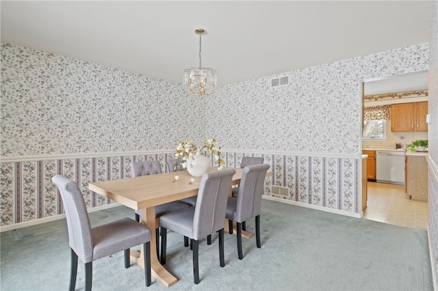 dining room featuring light colored carpet and a chandelier