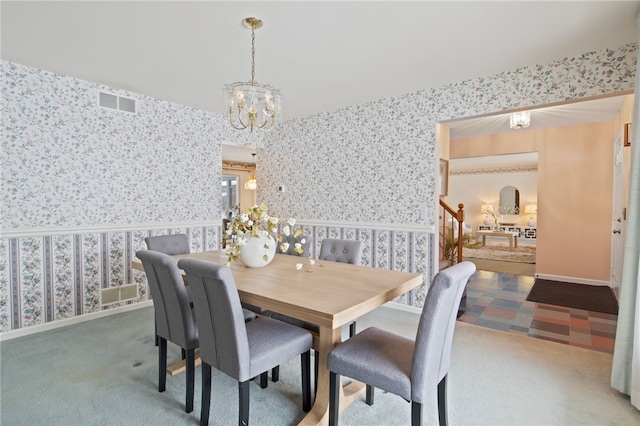 dining room with carpet and an inviting chandelier