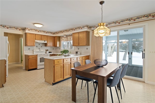 kitchen featuring white appliances and hanging light fixtures