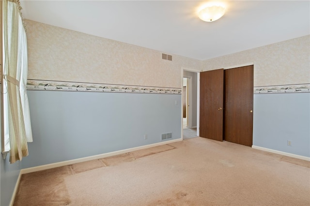 unfurnished bedroom with carpet floors and a closet