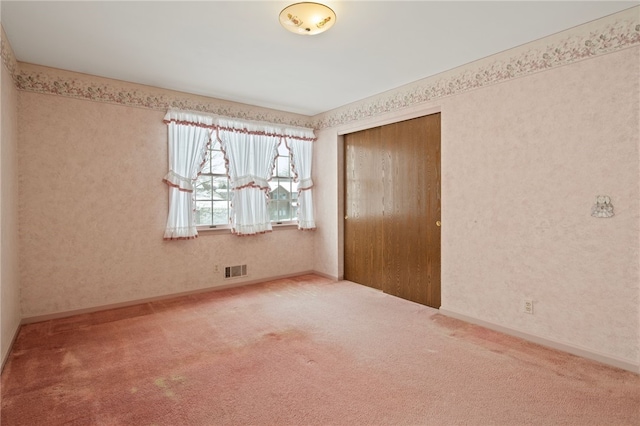 unfurnished bedroom featuring carpet flooring and a closet