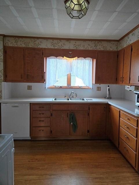 kitchen featuring hardwood / wood-style flooring, sink, white appliances, and ornamental molding