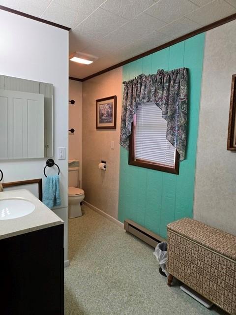 bathroom featuring toilet, baseboard heating, and vanity