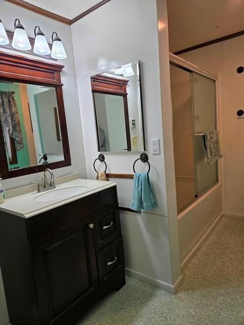 bathroom featuring vanity and bath / shower combo with glass door