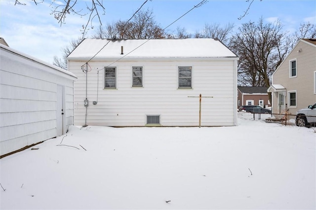 view of snow covered rear of property