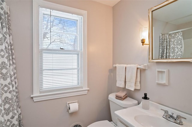 bathroom featuring a shower with curtain, vanity, and toilet