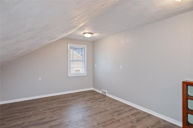 bonus room featuring lofted ceiling and dark hardwood / wood-style flooring