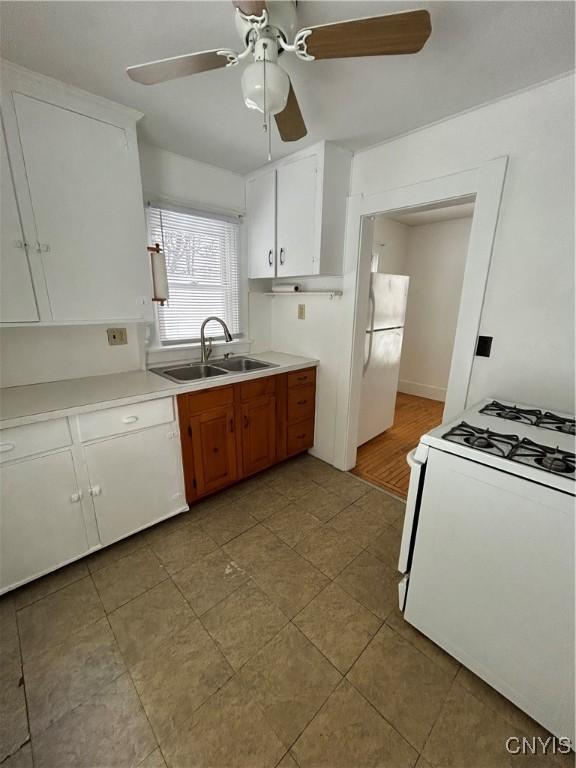 kitchen with ceiling fan, white appliances, sink, and white cabinets