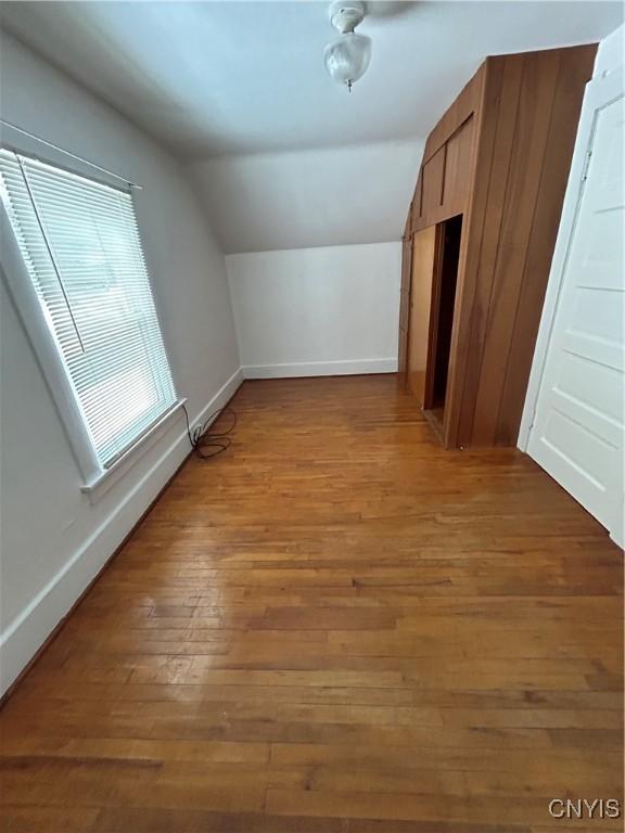 additional living space featuring lofted ceiling and hardwood / wood-style floors