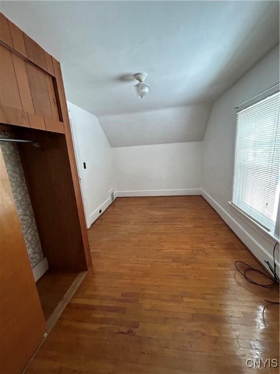 additional living space with lofted ceiling and hardwood / wood-style floors