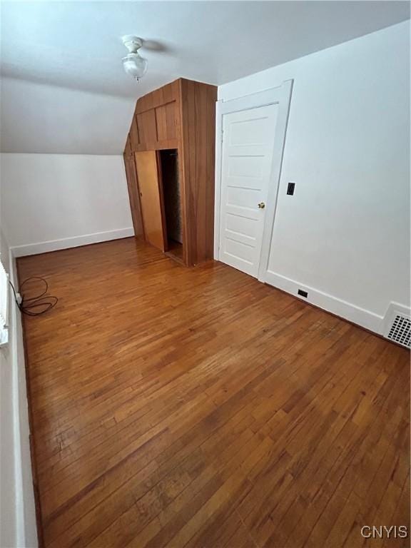 additional living space with lofted ceiling and dark hardwood / wood-style floors