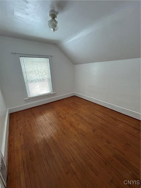 additional living space featuring wood-type flooring and vaulted ceiling