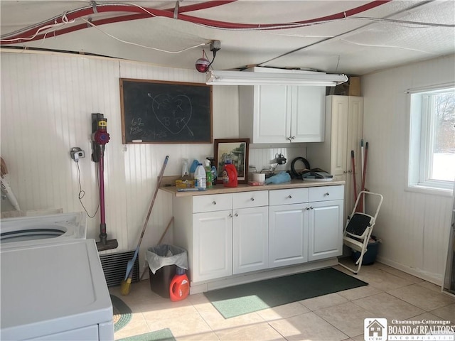 laundry area featuring light tile patterned floors, washer / clothes dryer, and cabinets