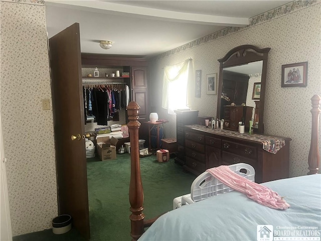 bedroom with beam ceiling, a closet, and dark colored carpet