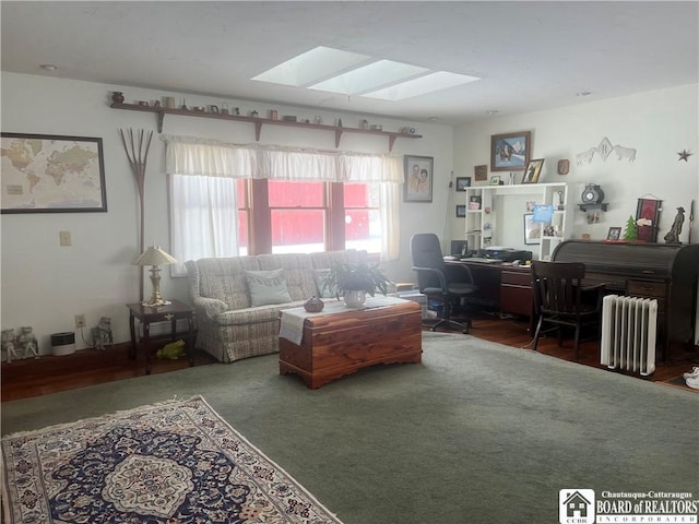 living room featuring radiator and a skylight