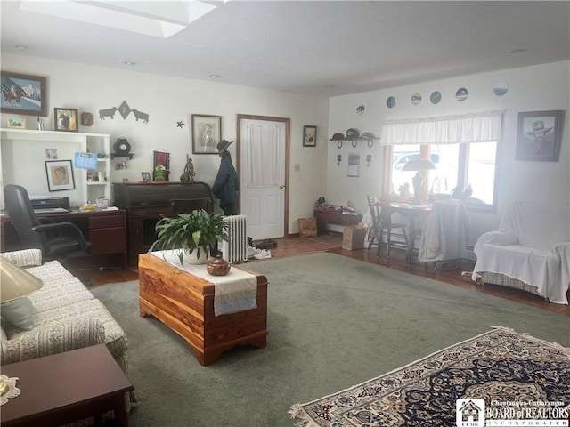 living room with dark hardwood / wood-style flooring, radiator, and a skylight