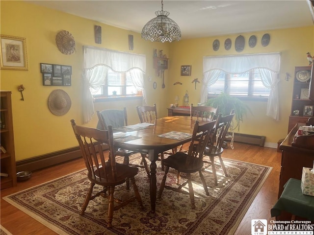 dining room featuring wood-type flooring and a baseboard radiator