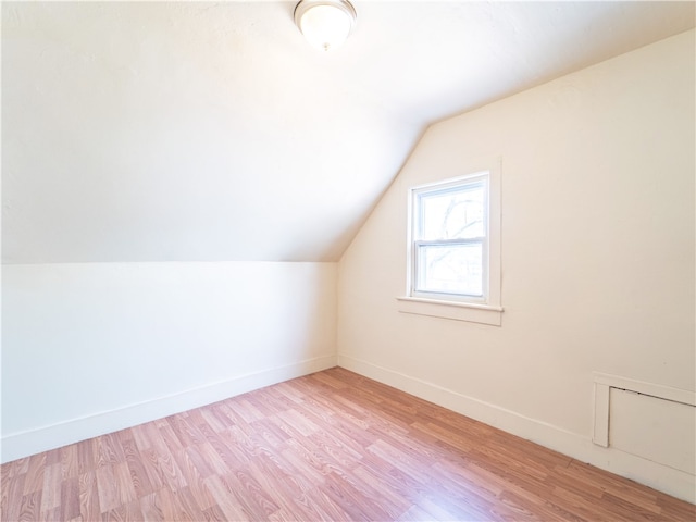 additional living space featuring vaulted ceiling and light hardwood / wood-style floors