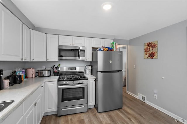 kitchen featuring white cabinetry, stainless steel appliances, and light hardwood / wood-style floors