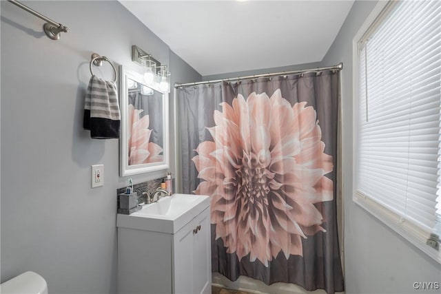 bathroom featuring vanity, curtained shower, and toilet