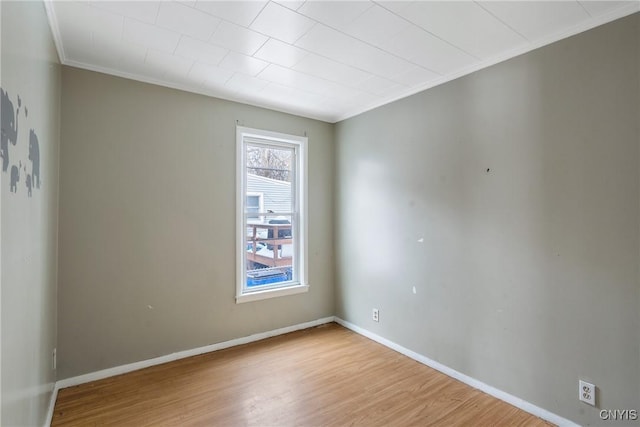 unfurnished room with ornamental molding and light wood-type flooring