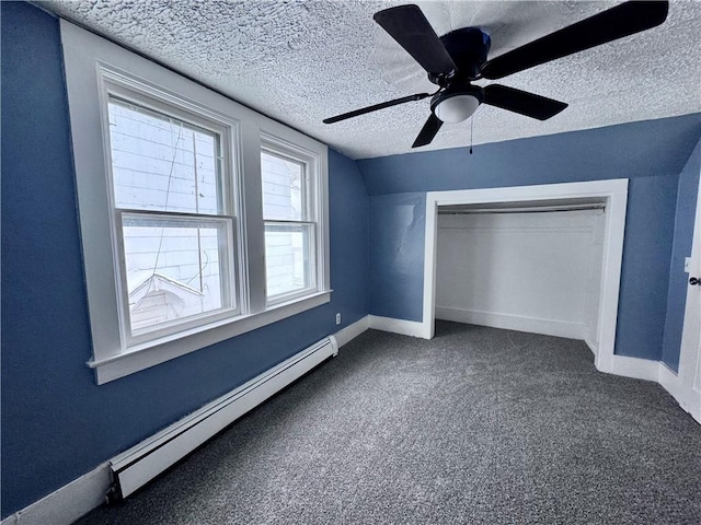 unfurnished bedroom with a textured ceiling, baseboard heating, carpet floors, a closet, and ceiling fan