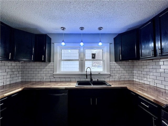 kitchen with tasteful backsplash, sink, butcher block countertops, and decorative light fixtures