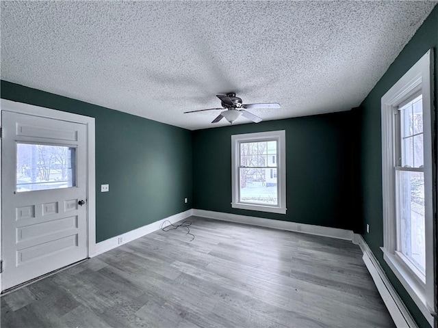 entrance foyer with ceiling fan, hardwood / wood-style floors, a textured ceiling, and a baseboard heating unit