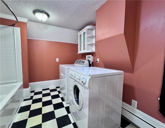 clothes washing area with separate washer and dryer and a textured ceiling