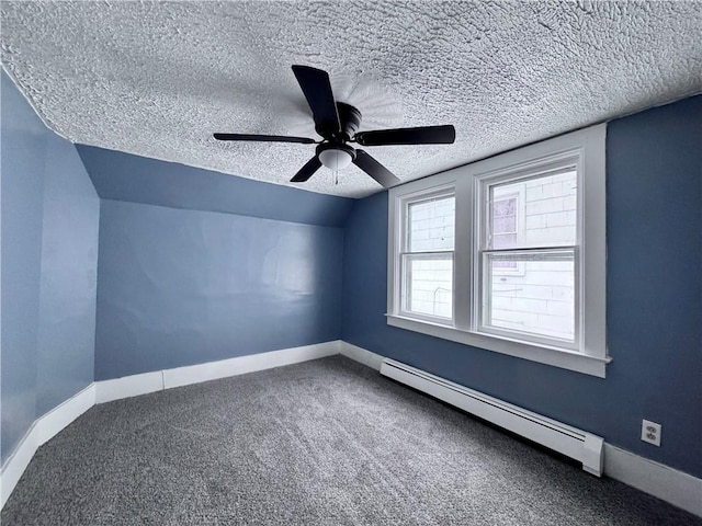 additional living space with vaulted ceiling, a textured ceiling, ceiling fan, carpet, and a baseboard heating unit