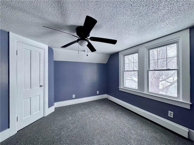 bonus room with ceiling fan, baseboard heating, dark colored carpet, a textured ceiling, and vaulted ceiling