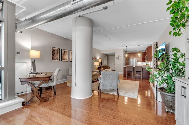 living room featuring decorative columns and light wood-type flooring