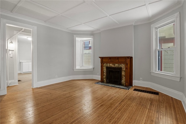 unfurnished living room featuring coffered ceiling, a premium fireplace, and light wood-type flooring