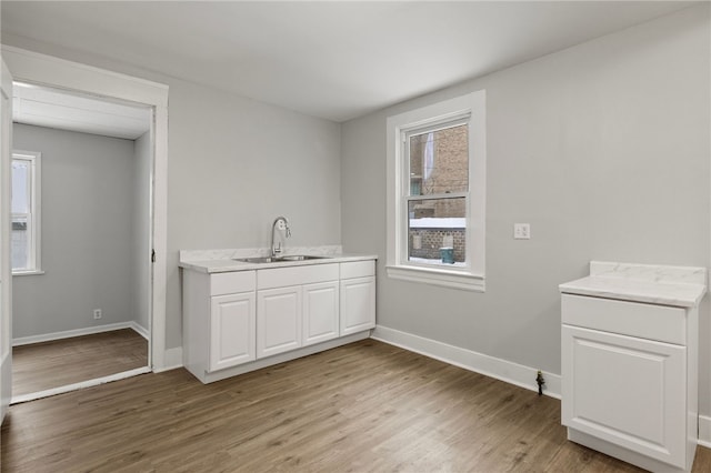 clothes washing area featuring sink and light wood-type flooring