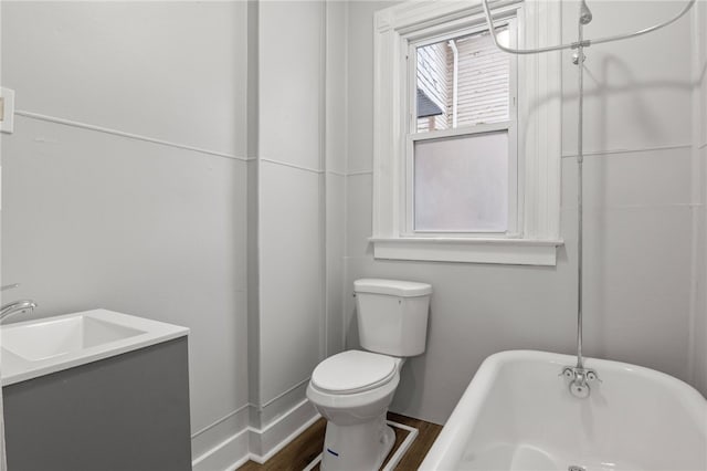 bathroom with toilet, a bath, sink, and hardwood / wood-style flooring