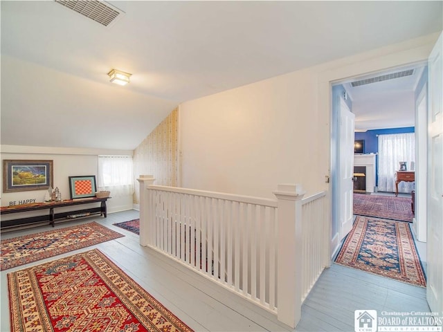 hallway featuring lofted ceiling and hardwood / wood-style floors