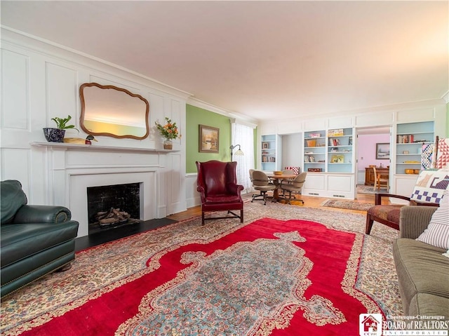 living room with hardwood / wood-style flooring, crown molding, and built in features