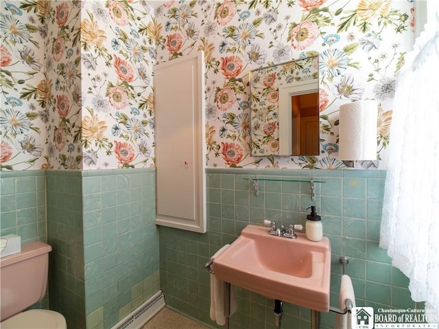 bathroom with sink, tile walls, and toilet